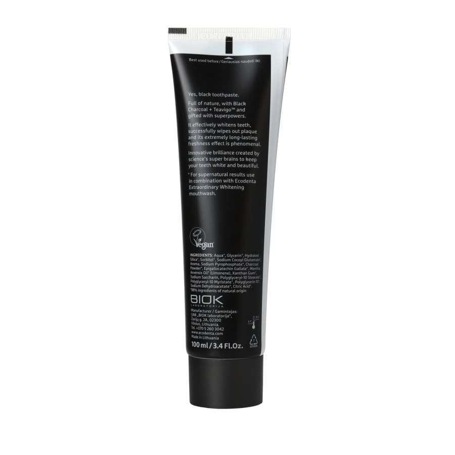 Ecodenta Black Whitening -valkaiseva hammastahna; musta putkilo pystyssä, kääntöpuolella valkoista tekstiä ainesosista, tuotetiedoista ja tilavuudesta 100 ml (3,4 fl. oz.); pinta sileä ja mattapintainen, lieriömäinen muoto; pinnalla vegaanimerkki ja kestävän pakkauksen kuvake; vaalea tausta, ei ihmisiä.