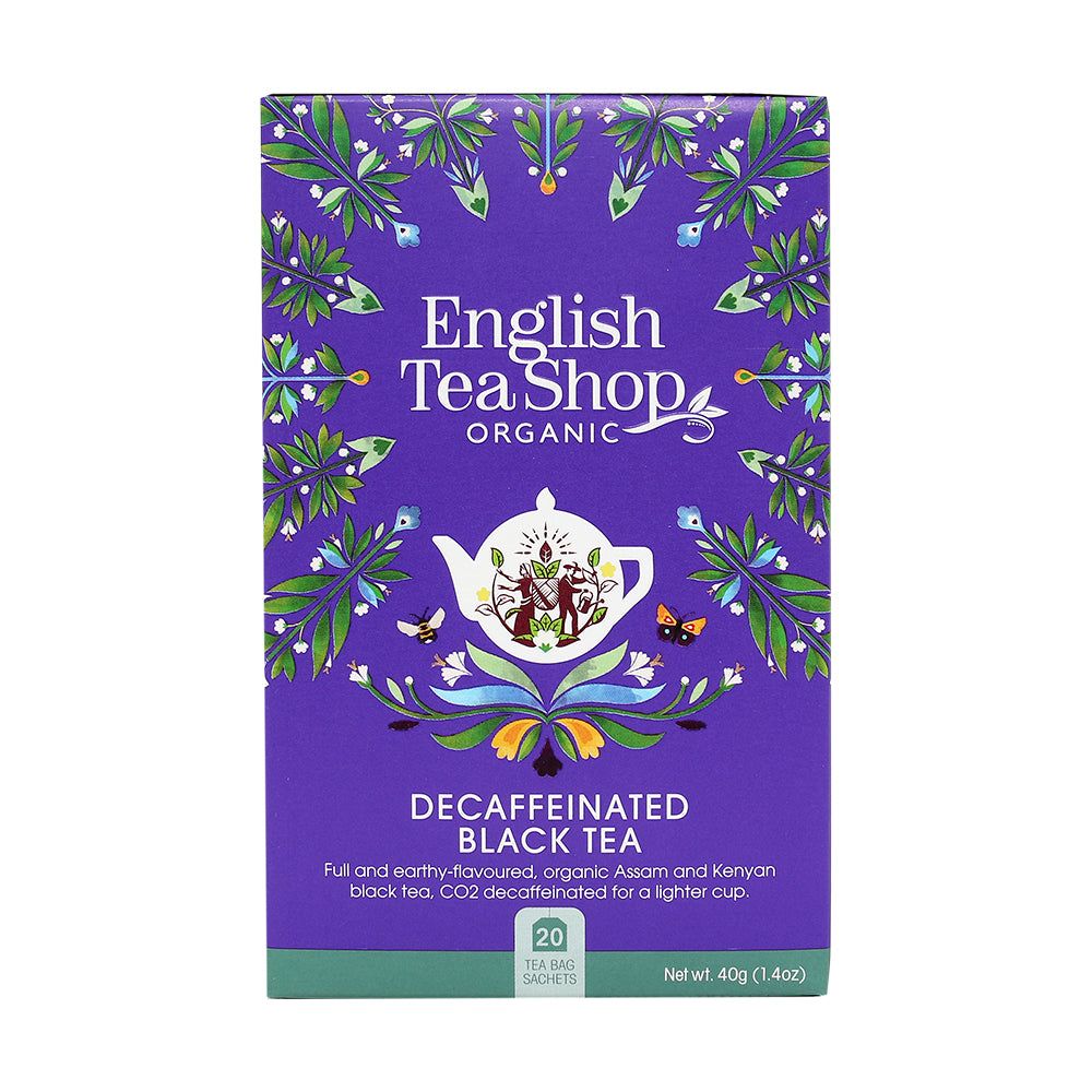 English Tea Shop Luomu Kofeiiniton Musta tee; violetti suorakulmainen mattapintainen pahvipakkaus, kuvituksena kukka- ja lehtikuvioita valkoisen, vihreän ja oranssin sävyissä; etupuolella valkoinen teekannukuvitus; groteskiteksti kertoo tuotteen olevan luomu ja kofeiiniton musta tee, sisältää 20 teepussia; vaalea tausta, ei ihmisiä tai käsiä kuvassa.