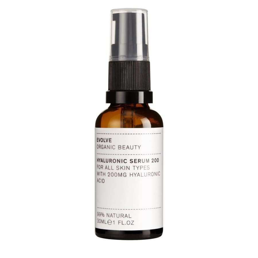 Evolve Hyaluronihapposeerumi -pullo, 30 ml; pieni, meripihkanvärinen ja sylinterimäinen pullo mustalla pumpulla; valkoisessa paperietiketissä yksinkertaista tekstausvapaata tekstiä 200 mg:n hyaluronihappopitoisuudesta ja 99-prosenttisesta luonnollisuudesta; pullo kuvattu pystyssä vaaleaa taustaa vasten, ei ihmisiä näkyvissä.