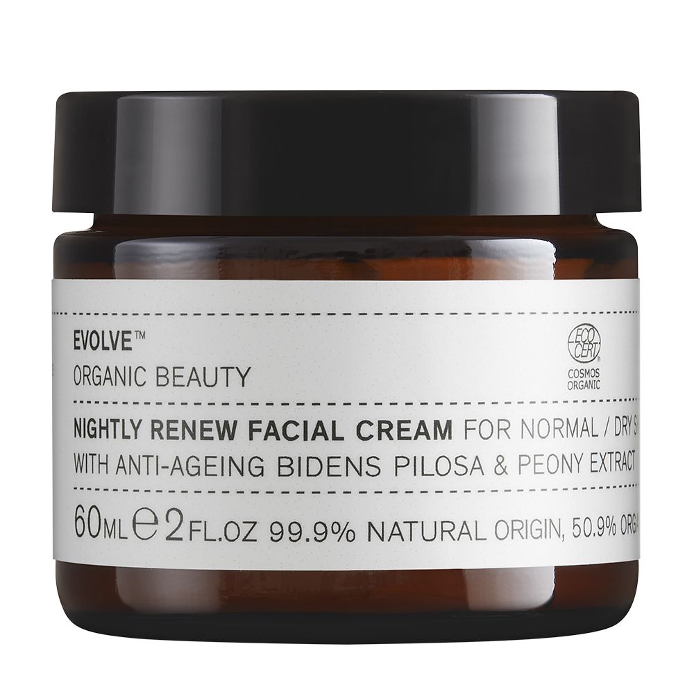 A brown glass jar with a black lid labeled Evolve Organic Beauty Nightly Renew Facial Cream for normal/dry skin, featuring bidens pilosa and peony extract, 60ml, formulated with 99.9% natural origin ingredients for radiant, healthy skin. The label uses simple black sans-serif text on a white background. The container is cylindrical and has a matte finish. No people or hands are visible. The product is photographed against a plain light-colored background in a centered shot.