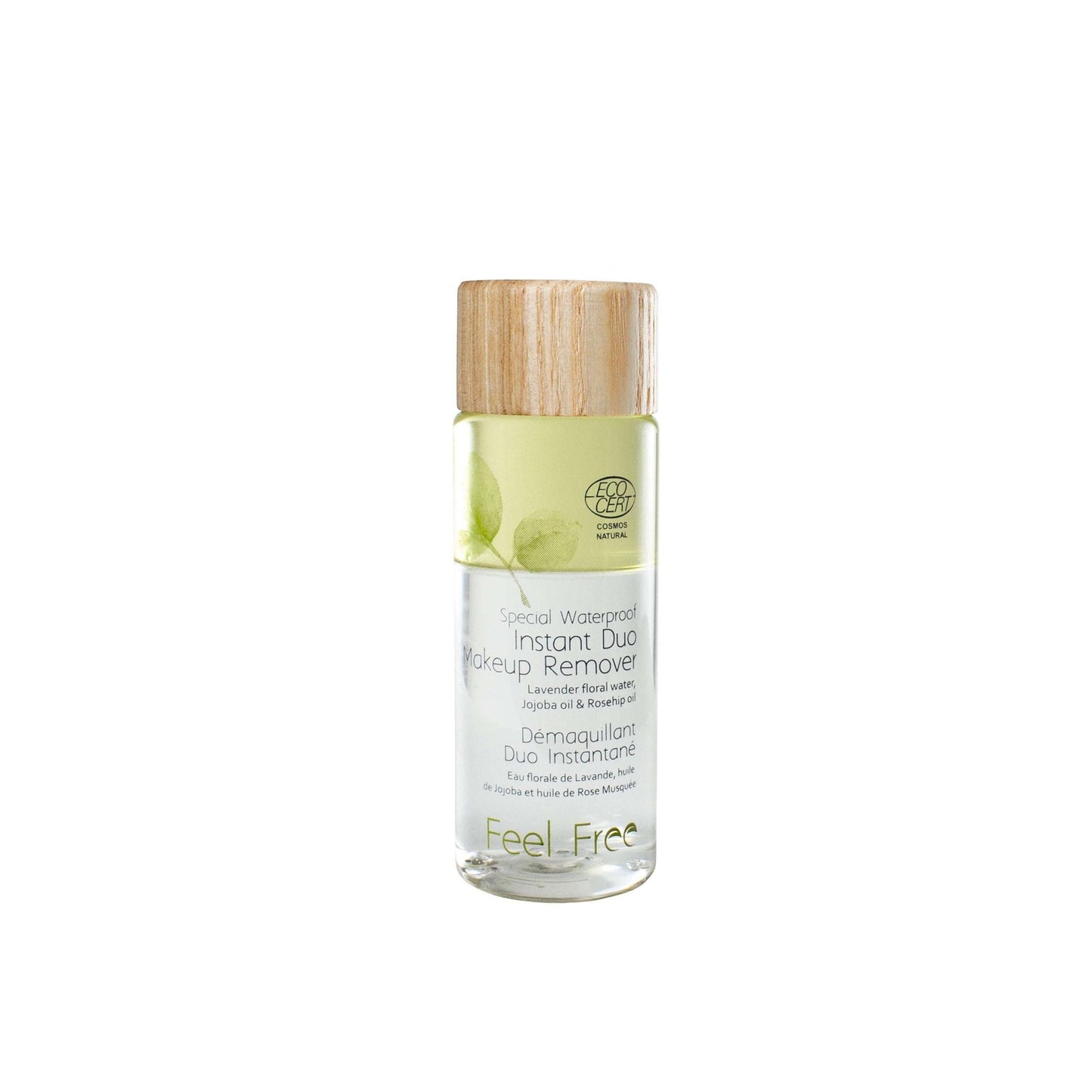 A clear cylindrical plastic bottle of Feel Free Instant Duo Makeup Remover with a matte-finish wooden screw cap. Label features green illustrated leaf designs and sans-serif printed text, including product name and mention of waterproof makeup removal for sensitive skin. The background is plain, white, and uncluttered. Bottle sits upright with no people or hands visible in the shot.