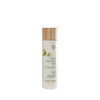 A bottle of Feel Free Facial Cleansing Milk with a wooden cap, cylindrical white body, and matte finish. Green leaf graphics printed on the front. Visible label includes both English and French text in a clean sans-serif font style. The item is set against a plain white background with no additional objects or people present. Camera is at eye level, product fills most of frame.