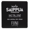 Fiini Naturally Suolasaippua Tuoksuton; musta suorakulmainen mattapintainen pakkaus vaalealla taustalla; etiketissä yksinkertainen valkoinen groteskiteksti, joka kertoo tuotteen olevan tuoksuton, 100-prosenttisesti luonnollinen ja vegaaninen, tekstit suomeksi, ruotsiksi ja englanniksi; ei ihmisiä tai muita esineitä kuvassa.