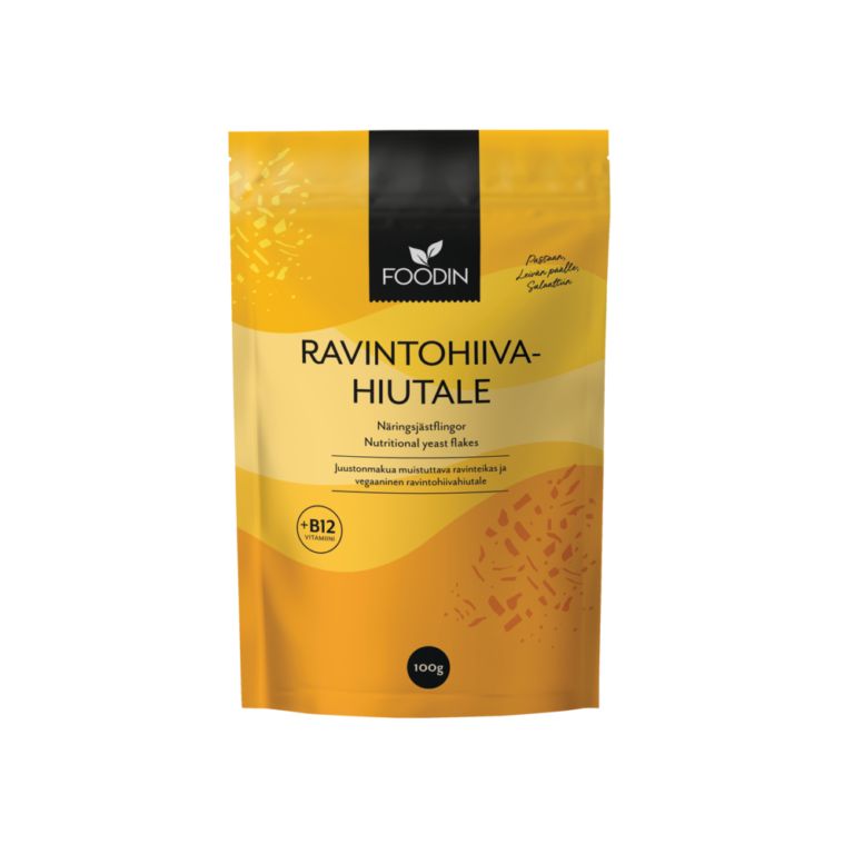 Foodin Ravintohiivahiutale +B12, 100 g; keltaoranssi pakkaus, suomen- ja englanninkielistä tekstiä, uudelleensuljettava yläreuna; mattapintainen, pystysuora, pyöristetyin kulmin joustopussi; pääteksti lihavoidulla valkoisella groteskifontilla vaalealla tai luonnonvalkoisella taustalla; tuote seisoo pystyssä neutraalilla tasaisella pinnalla, ei ihmisiä tai rekvisiittaa.