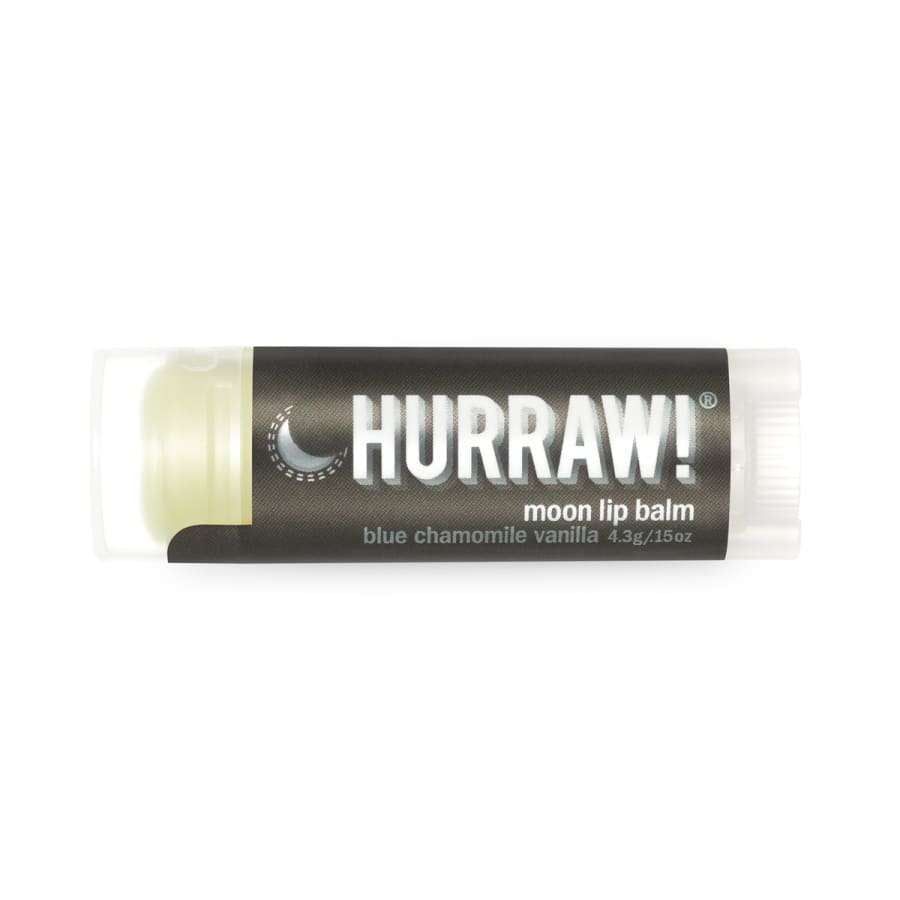 Hurraw! Huulivoide Moon Balm -tuubi, tumma etiketti, valkoinen teksti, sylinterinmuotoinen mattamuovi pyöristetyin reunoin; groteskiteksti tuotenimestä ja sinikamomillan-vaniljan mausta