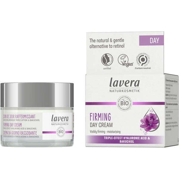 A cylindrical glass jar with a white matte lid and a rectangular cardboard box, both labeled Lavera Firming Day Cream. Visible text includes vegan, carbon-neutral, hyaluronic acid, bakuchiol; box highlights as natural retinol alternative. Background is plain; no people present. Typography is bold sans-serif on white surfaces.