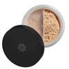 A round container of mineral loose powder foundation with a black matte-finish lid, partially open, revealing light tan powder inside divided by a white plastic inner separator. No visible branding or label text. The product sits against a plain, neutral background in a close-up shot. No people or hands are present.
