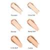 Six swatches of face powder labeled: Porcelain, China Doll, Blondie, Barely Buff, In the Buff, and Cookie. Each swatch shows a distinct light to medium beige shade with a matte surface. The powders are arranged side by side on a plain white background. Labels use simple sans-serif font in black text. No packaging, people, or other objects are visible.