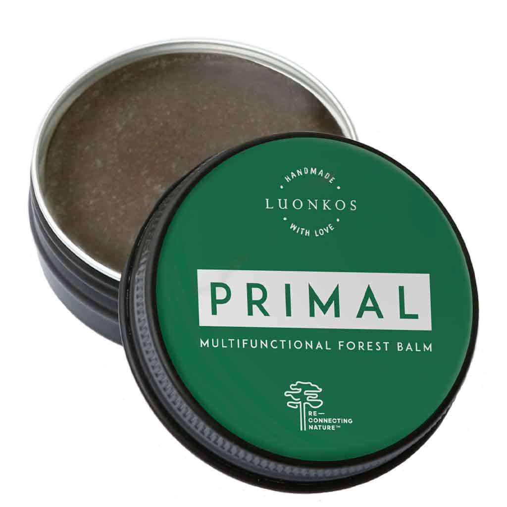 Luonkos PRIMAL Metsämikrobivoide; avattu purkki paljastaa hoitavan ruskean balmin; pyöreä metallipurkki mattapintainen vihreällä kannella ja valkoisella groteskitekstillä; balmi sileän ja tasavärinen; neutraali tausta, tuote täyttää kuva-alan, ei ihmisiä tai käsiä; suomalaisten metsien inspiroima balmi.