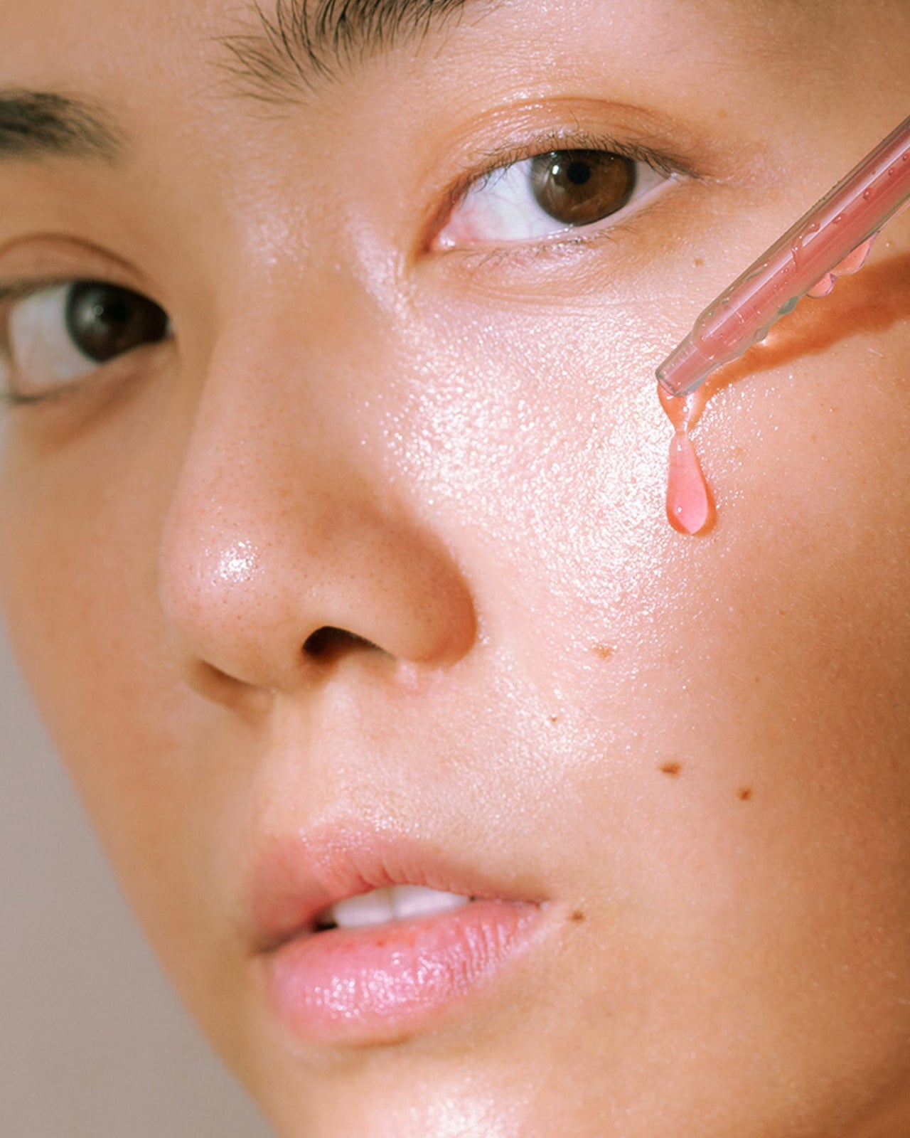 Madara PEEL Hyaluron Intense Kuoriva seerumi; malli, jonka kasvoille levitetään seerumia tiputtimella