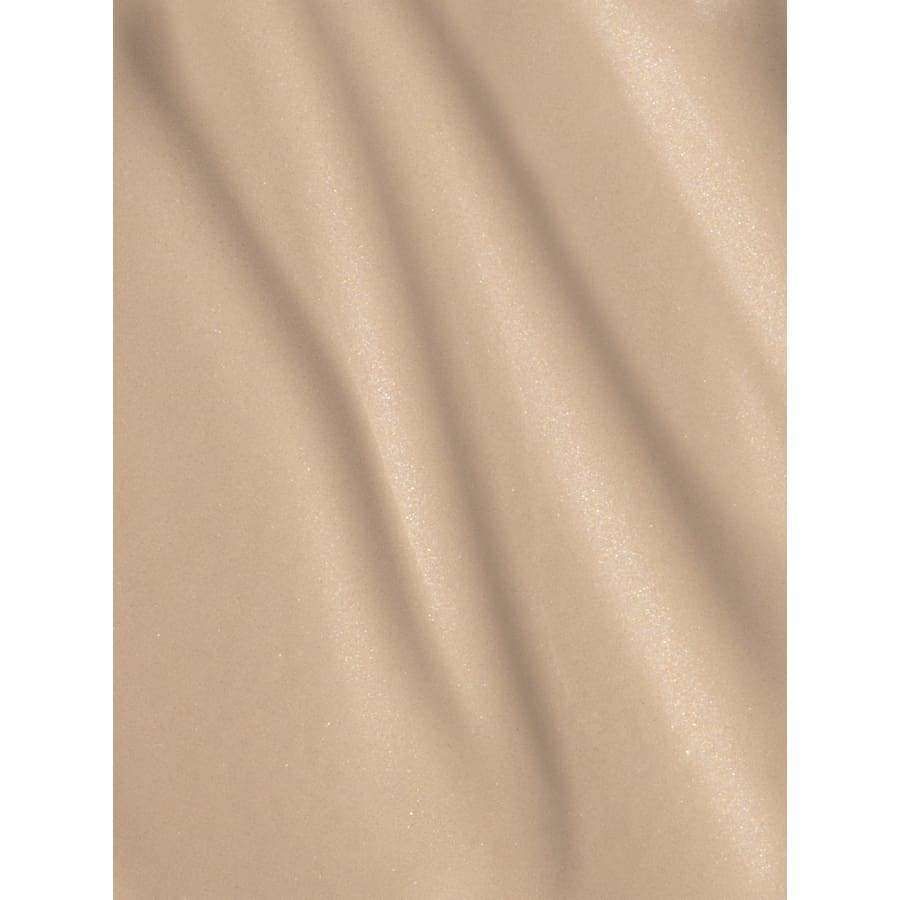 MÁDARA Skin Equal Meikkivoide, sävy Ivory; beige, hieman kiiltävä pellava pehmein, vinoin laskoksin, sileä pinta; suorakulmainen kangaspala löyhästi aseteltuna; ei pakkausta tai etikettiä; ei ihmisiä tai käsiä.