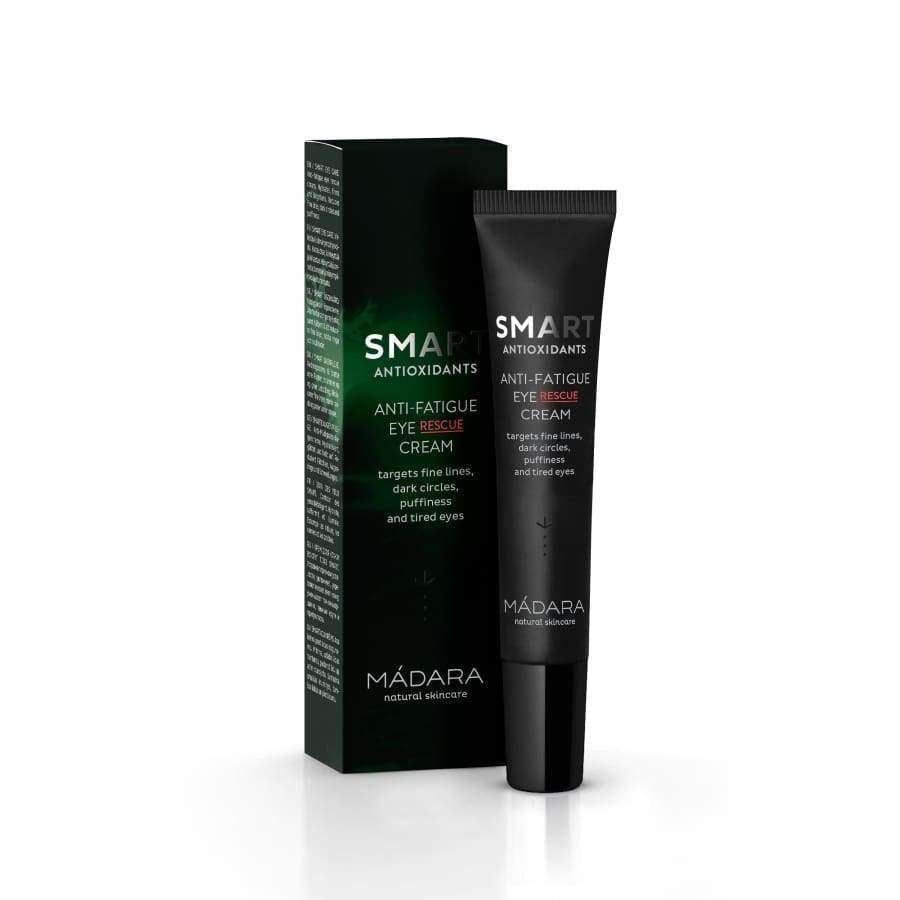 Mádara SMART Anti-Fatigue Eye Rescue Silmänympärysvoide -tuubi ja pakkaus; molemmat mustia vihrein korostuksin, pystyssä rinnakkain aseteltuina; mattapintainen viimeistely; valkoista tekstausvapaata tekstiä, joka kertoo antioksidanttipitoisesta ihonhoitotuotteesta hienojen juonteiden, silmänalusten, turvotuksen ja väsyneen ilmeen hoitoon; kuvattu neutraalia taustaa vasten, ei ihmisiä tai muita esineitä.