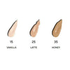 MÁDARA The Concealer; kolme peitevoidenäytettä nimillä "Vanilla (15)", "Latte (25)" ja "Honey (35)", vaaleasta keskisävyyn ja tummempaan ruskehtavaan, aseteltuna virheettömälle valkoiselle taustalle vertailua varten; näytteet kermaisia, sileitä, soikeanmuotoisia; teksti selkeällä groteskifontilla kunkin näytteen yllä tai vieressä; ei käsiä tai ihmisiä.