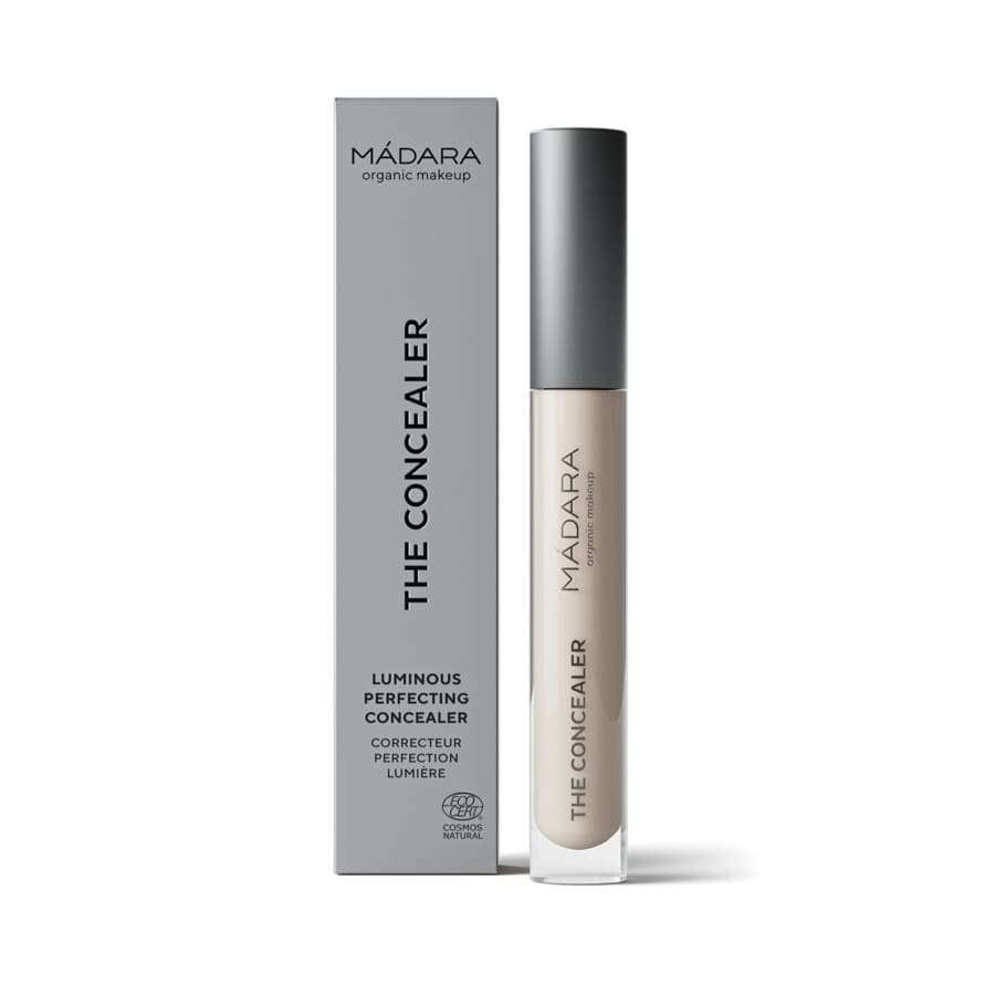 MÁDARA The Concealer, sävy Vanilla; putkilo harmaan suorakulmaisen rasian vieressä; molemmat sileäpintaisia ja mattaisia; putkilo lieriömäinen yksinkertaisella korkilla, rasia terävin reunoin pystyssä; groteskitekstillä lukee "Luminous Perfecting Concealer"; vaalea tausta, ei ihmisiä; tuote keskitetty kuvassa.