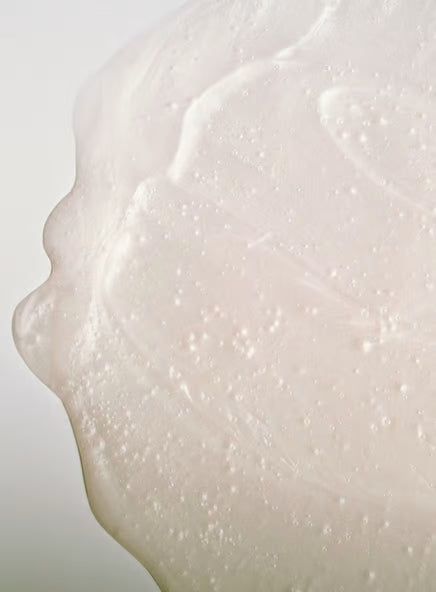 Close-up of a translucent, textured, and slightly bubbly surface that appears to be a dollop of hydrating skin-care gel or serum against a light background. Product type: gel or serum. Color: clear with possible slight tint. Material: viscous liquid. Surface finish: glossy. Shape: amorphous dollop. No packaging visible; no label text, typography, people, or hands in frame.
