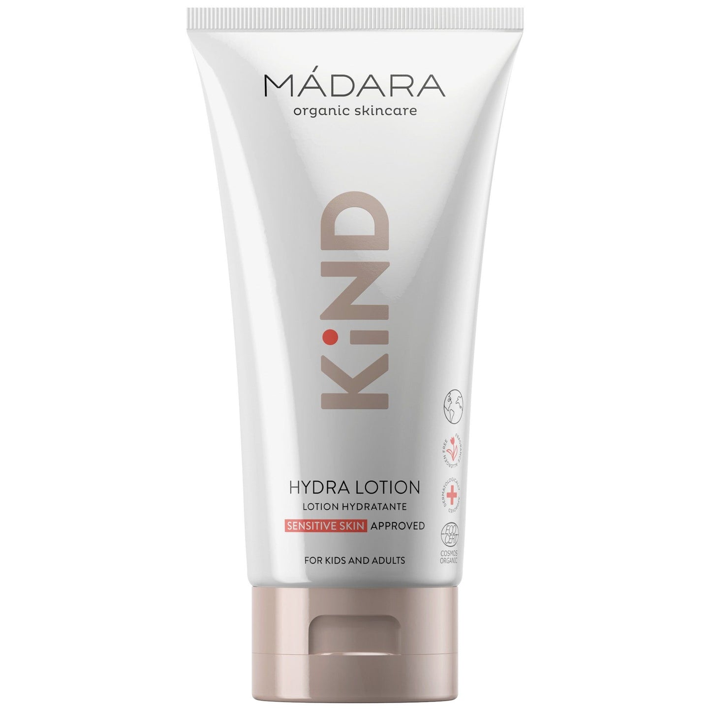 A white tube of MÁDARA organic skincare KIND Hydra Lotion for sensitive skin, labeled for kids and adults. The packaging features soft pink and gray geometric accents with product information in both English and French. Matte finish on the tube, upright cylindrical shape with a flat flip cap. Sans-serif bold black typography is used. Plain background, no visible people or hands, centered product shot.