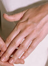 A close-up of a person’s hands with clean, natural nails gently resting on each other against a light background, highlighting well-groomed fingertips. No visible objects, labels, or packaging. Nails are short and smooth with no polish. Background is plain and evenly lit. Only hands are in the frame; no other products or text present.