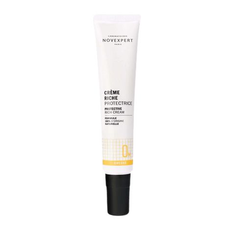 Novexpert OMEGA Rich Protective Cream; valkoinen tuubi Novexpert Crème Riche Protectrice -kasvovoidetta mustalla korkilla, keltaisin tehostein ja mustalla tekstillä, ravitsevin ainesosin, pystyssä vaaleaa taustaa vasten; pinta mattainen, tuubi sylinterinmuotoinen tasaisella korkilla; etiketin teksti selkeällä groteskikirjasimella eri painoin; ei ihmisiä tai käsiä kuvassa, keskitetty ja hyvin valaistu kuva vain yhdestä tuotteesta.