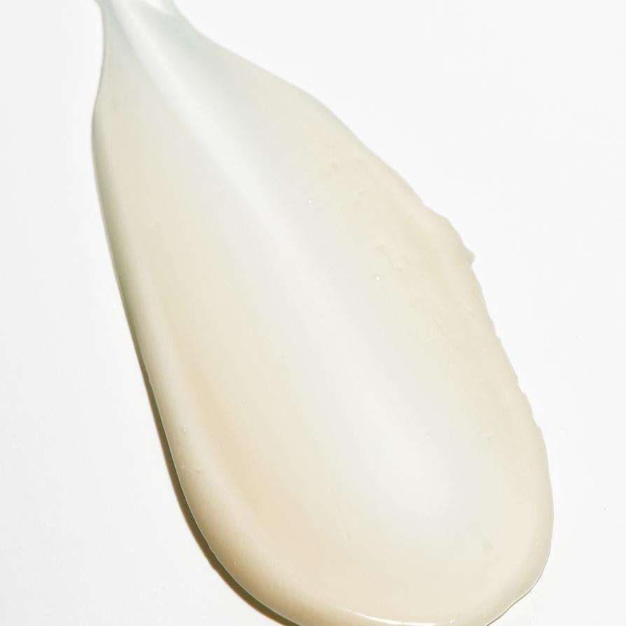 Novexpert PRO-COLLAGEN Expert Anti-Aging Eye Contour; lähikuva sileästä kermaisesta beigen sävyisestä kosteusvoiteesta levitettynä valkoiselle alustalle; tuote puolikiiltävä ilman näkyvää pakkausta tai etikettiä; valkoinen tausta, ei ihmisiä tai käsiä kuvassa.