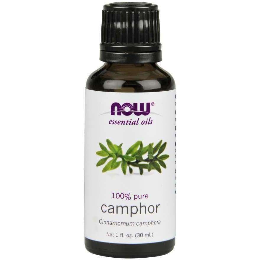 NOW Essential Oils 100% Pure Camphor (Cinnamomum camphora), 1 fl. oz. (30 mL); ruskea, lieriömäinen, kiiltäväpintainen pullo; etiketissä kuva vihreistä lehdistä sekä selkeää groteskitekstiä valkoisella pohjalla; tekstissä mainitaan tilavuus ja "pure oil"; vaalea tausta, ei ihmisiä.