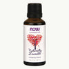 NOW Essential Oils Naturally Loveable -romanttinen öljyseos, 1 oz; kiiltäväpintainen, meripihkanvärinen lasipullo; valkoisessa etiketissä teksti "romance blend" groteskifontilla sekä kuvitus punaisista sydämistä muodostuvasta puusta; musta uritettu korkki; ei ihmisiä; vaalea tausta, tuote kuvattu silmän tasolta.