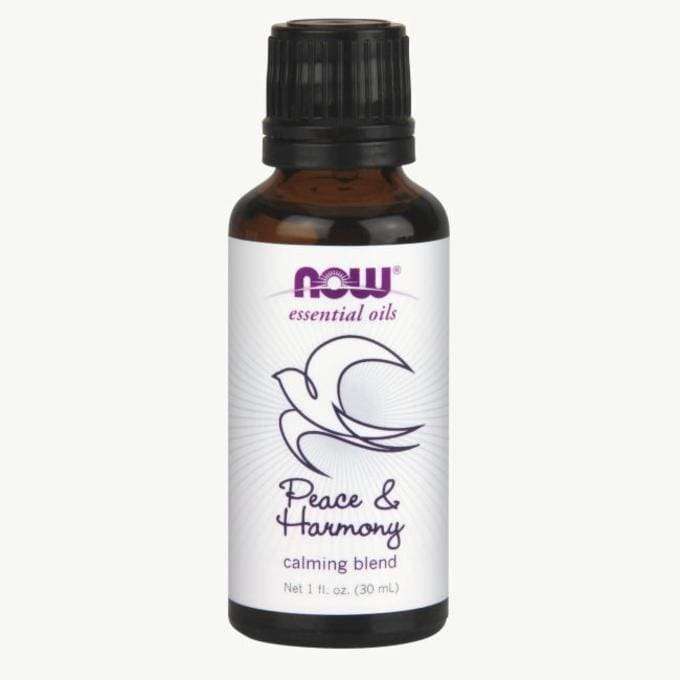 NOW Essential Oils Peace & Harmony -rauhoittava öljyseos, 1 fl. oz. (30 mL); ruskea pullo, matta musta muovikorkki; etiketissä kyyhkyskuvitus, violettia ja vihreää sekatyylistä groteskitekstiä sekä viivagrafiikkaa; tuote seisoo pystyssä vaalealla taustalla, ei ihmisiä.