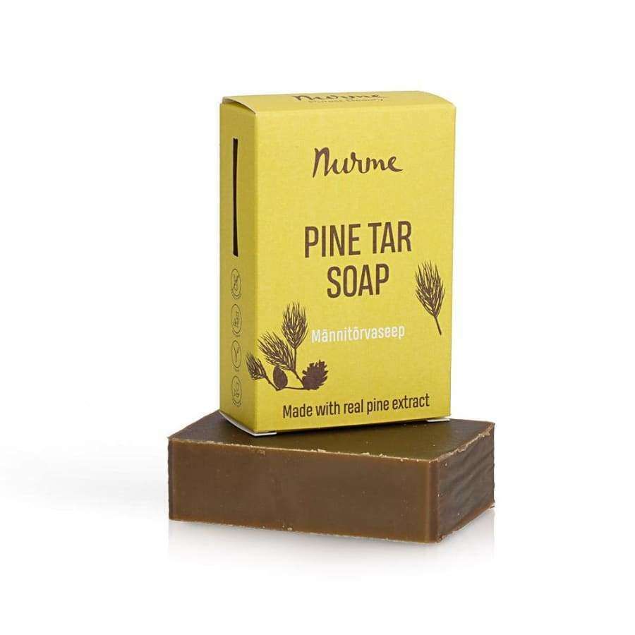Nurme Palasaippua Mäntyterva -pakkaus ja saippuapala, keltainen suorakulmainen rasia tummanvihrein mäntyoksakuvituksin, mattapintainen ruskea saippuapala; groteskiteksti "Made with real pine extract"