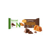 Nutrilett Ateriankorvikepatukka, Milk Chocolate & Creamy Caramel; patukka kääreessään suklaa- ja karamellipalojen vieressä; suorakulmainen patukka kiiltävässä pakkauksessa, jossa painettua brändi- ja kuvaustekstiä ruskean, kullanvärisen ja valkoisen sävyin; lihavoitu groteskifontti kääreessä; vaalea tausta, ei ihmisiä; kuvattu edestäpäin.