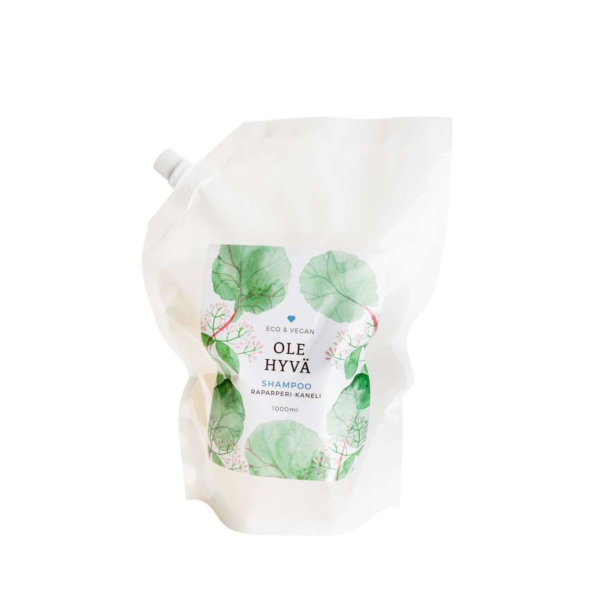 Ole Hyvä Shampoo Raparperi-Kaneli -täyttöpussi, 1000 ml; valkoinen, mattapintainen ja joustava muovipussi vihreällä lehtikuviolla ja nokkakorkilla; etiketissä tuotenimi, tuoksu ja tilavuus selkeällä tekstausvapaalla kirjasimella; kuvattu keskitettynä suoraan edestä neutraalia taustaa vasten, ei ihmisiä tai käsiä näkyvissä.