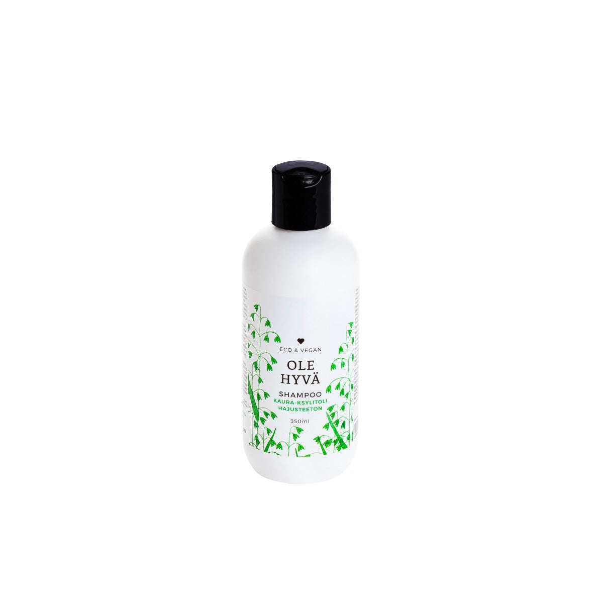 Ole Hyvä Hajusteeton Shampoo Kaura-Ksylitoli -pullo; valkoinen, sileä ja mattapintainen sylinterimäinen muovipullo kiiltävän mustalla korkilla; etiketissä vihreitä lehtikuvituksia ja tuotenimi yksinkertaisella tekstausvapaalla kirjasimella; kuvattu keskitettynä valkoista taustaa vasten ilman ihmisiä tai käsiä.