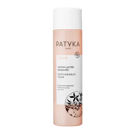 Patyka Paris Soothing Milky Toner -pullo, vaaleanpunainen ja valkoinen etiketti, kasviuutekuvituksia ja tuotetietoja etupuolella; valkoinen sylinterimäinen muovipullo mattapinnalla; etiketissä mustaa tekstausvapaata typografiaa brändinimelle ja tuotteelle, kasvipiirrokset viivataidetta; läpinäkyvä muovikorkki; pystyssä oleva studiokuva yksinkertaista taustaa vasten; ei ihmisiä tai käsiä näkyvissä.