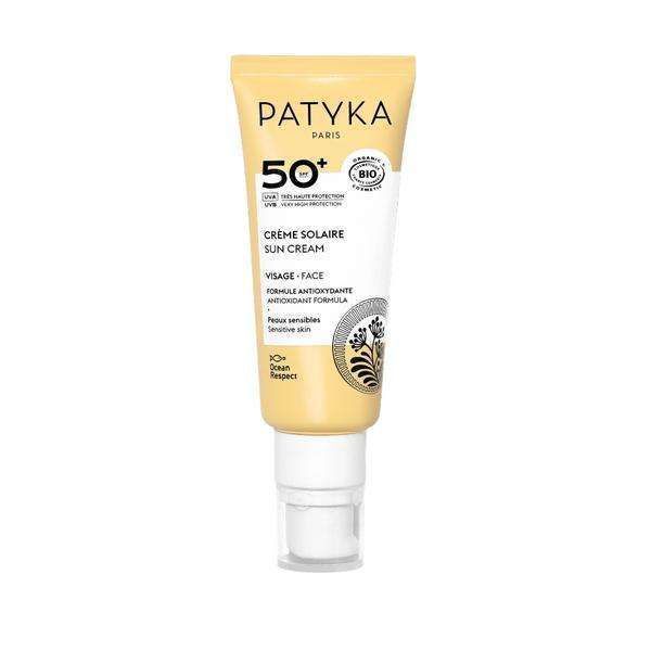 Patyka Face Sun Cream SPF50+ Aurinkovoide kasvoille; tuubi Patyka Paris SPF 50+ -aurinkovoidetta herkälle iholle, valkoisen ja keltaisen suunnittelun kera pumppuannostelijalla; pakkaus mattapintainen; musta ja keltainen teksti etiketissä lukee "SPF 50+" ja viittaa antioksidanttikoostumukseen sekä valtamerten kunnioittamiseen; ei ihmisiä kuvassa; tuote kuvattu vaaleaa taustaa vasten.