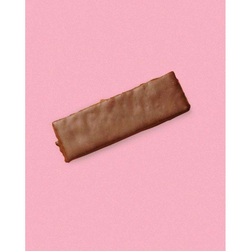 Puhdistamo Kollageeni Protein Bar, vadelma; yksittäinen suklaakuorrutteinen suorakulmainen keksi keskellä vaaleanpunaista taustaa, kaakaokuorrutuksen kiilto korostettuna; keksi sileä- ja suoravreunainen, pinta tasainen; ei näkyvää pakkausta, etikettiä tai tekstiä; kuva otettu ylhäältä, ei ihmisiä tai käsiä.
