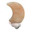 A crescent moon-shaped Himalayan salt night light with a matte, textured orange-pink surface is plugged into a white wall electrical outlet. The product is not in packaging. There is no visible label or typography. The setting includes part of a plain wall and outlet, with no people or hands present. This is a close-up shot. A crescent moon-shaped Himalayan salt night light gently glows while plugged into a white electrical outlet, adding a calming ambiance to any room.