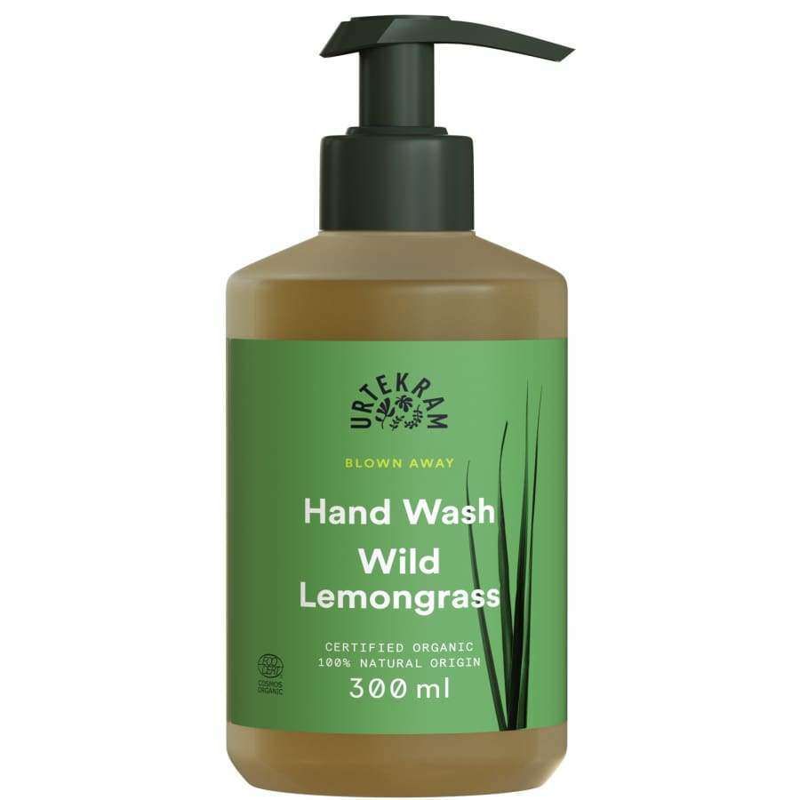 Urtekram Blown Away Wild Lemongrass Käsisaippua; Urtekram Blown Away Hand Wash Wild Lemongrass -pullo vihreällä etiketillä ja kätevällä pumppuannostelijalla, sisältää 300 ml sertifioitua luomua sitruunaruohokäsisaippuaa; pullo läpinäkymätöntä luonnonvalkoista muovia, lieriömäinen pyöristetyin olkapäin; vihreässä mattaetiketissä tuotenimi suurin valkoisin groteskikirjaimin, tarkempaa tekstiä alapuolella; vaalea tausta, ei ihmisiä tai käsiä.