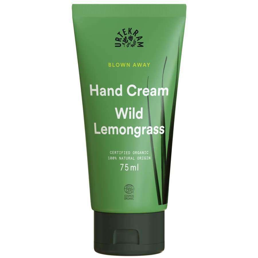 Urtekram Blown Away Wild Lemongrass Käsivoide; vihreä Urtekram Hand Cream Wild Lemongrass -tuubi, 75 ml, sertifiointilogoja ja yksinkertainen heinäkuvitus, vaalealla taustalla; tuubi lieriömäinen mattapinnalla, läppäkorkki; valkoinen groteskiteksti näyttää tuotenimen ja koon; ei ihmisiä tai käsiä kuvassa.