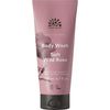 Urtekram Dare to Dream Soft Wild Rose Suihkusaippua; vaaleanpunainen, mattapintainen muovituubi tekstillä "Urtekram Nordic Beauty Body Wash, Soft Wild Rose, 200 ml", keskitettynä kuvaan; etuosassa valkoisia kukkakuvituksia ja vegaani- sekä luomusertifiointisymboleita; tuotetyyppi ja tilavuus painettu selkeällä groteskifontilla; ei ihmisiä tai käsiä; tausta yksinkertainen ja neutraali.