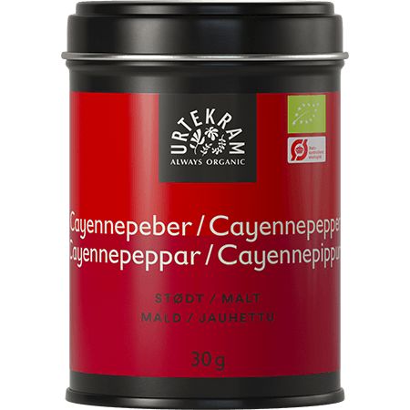 Urtekram Luomu Cayennepippuri; musta-punainen mausterasia tekstillä "Urtekram Cayennepeber, Cayennepepper, Cayennepeppar, Cayennepippuri", sisältää 30 g luomucayennepippuria; rasia suorakulmainen metallia mattapinnalla; etikettiteksti lihavoitua groteskia valkoisena; kuvassa vain rasia vaaleaa taustaa vasten, ei ihmisiä tai muita esineitä.