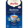 YogiTea Luomu Bedtime -teepakkaus; kuvassa teekuppi ja kamomillankukkia; suorakulmainen pahvipakkaus mattapinnalla, pääväri sininen ja keltainen; luettavassa etiketissä teksti "Ayurvedic blend", "naturally caffeine free", "17 teabags"; serif-fontti tuotenimessä, tekstausvapaata fonttia yksityiskohdissa; tausta valkoinen; ei ihmisiä tai käsiä näkyvissä; kuva otettu edestä silmän tasolta.