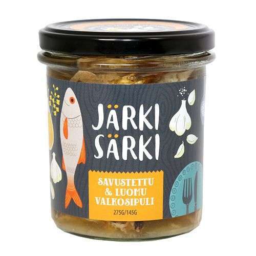 Järki Särki Savustettu & Luomuvalkosipuli; purkki Järki Särki -savustettua luomuvalkosipulikalaa, eloisin kuvituksin kalasta, valkosipulinkynsistä ja lautasista etiketissä; purkki kirkasta lasia metallikannella, pyöreä ja kiiltäväpintainen; etiketin tausta valkoinen värikkäin graafisin elementein ja lihavoidulla groteskikirjasimella tuotenimelle; nettopaino 275 g/145 g painettuna etikettiin; tuote eristettynä pelkistetyllä vaalealla taustalla.