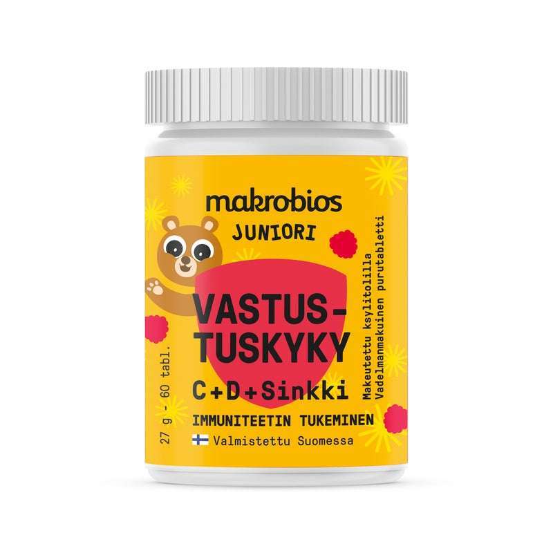 Makrobios Juniori Vastustuskyky; keltainen muovipullo Makrobios Juniori -tabletteja sylinterinmuotoisena kiiltäväpintaisena; etiketissä piirroskarhu, punainen ja musta teksti sekä suomenkielinen luettelo C- ja D-vitamiinista sekä sinkistä; lihavoitu groteskikirjasin tuotenimelle; vain pullo näkyvissä valkoisella taustalla, ei ihmisiä tai käsiä kuvassa.