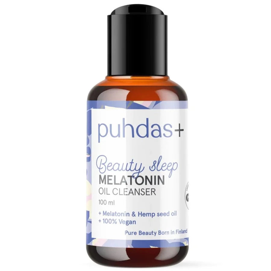 Puhdas+ Beauty Sleep Melatonin Oil Cleanser; ruskea, lieriön muotoinen pullo mattapintaisena mustalla kannella; valkoinen etiketti kietoutuu pullon ympäri tekstillä "Puhdas+ Beauty Sleep Melatonin Oil Cleanser, 100 ml" yksinkertaisella groteskifontilla; sinisiä ja violetteja väriaksentteja etiketissä; tuote kuvattu yksin neutraalilla taustalla.