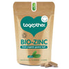 Together Health Bio-Zinc; ruskea mattapintainen pussi tekstillä "BIO-ZINC" luomuguavanlehdestä, valkoinen ja vihreä groteskiteksti; luettavassa tekstissä mainitaan 30 kasviskapselia ja luonnollinen, luomu- sekä hyvin biosaatavilla oleva sinkki; kaksi beigeä kapselia neutraalilla alustalla pystyssä olevan pussin edessä; studiovalaistus, vaalea tausta, ei ihmisiä tai käsiä.