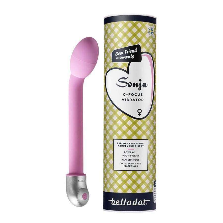 Belladot Sonja G-piste Vibrattori; vaaleanpunainen, mattapintainen G-piste-vibraattori kaartuvalla kärjellä seisoo pystyssä; vieressä lieriömäinen pakkaus vihreä-valkoisin ruutukuvioin, sydänkuvio ja teksti "Sonja G-Focus Vibrator by Belladot" lihavoidulla groteskifontilla; etiketissä pientä lisätuotetietoa; ei ihmisiä tai käsiä; neutraali tausta, studiokuva.