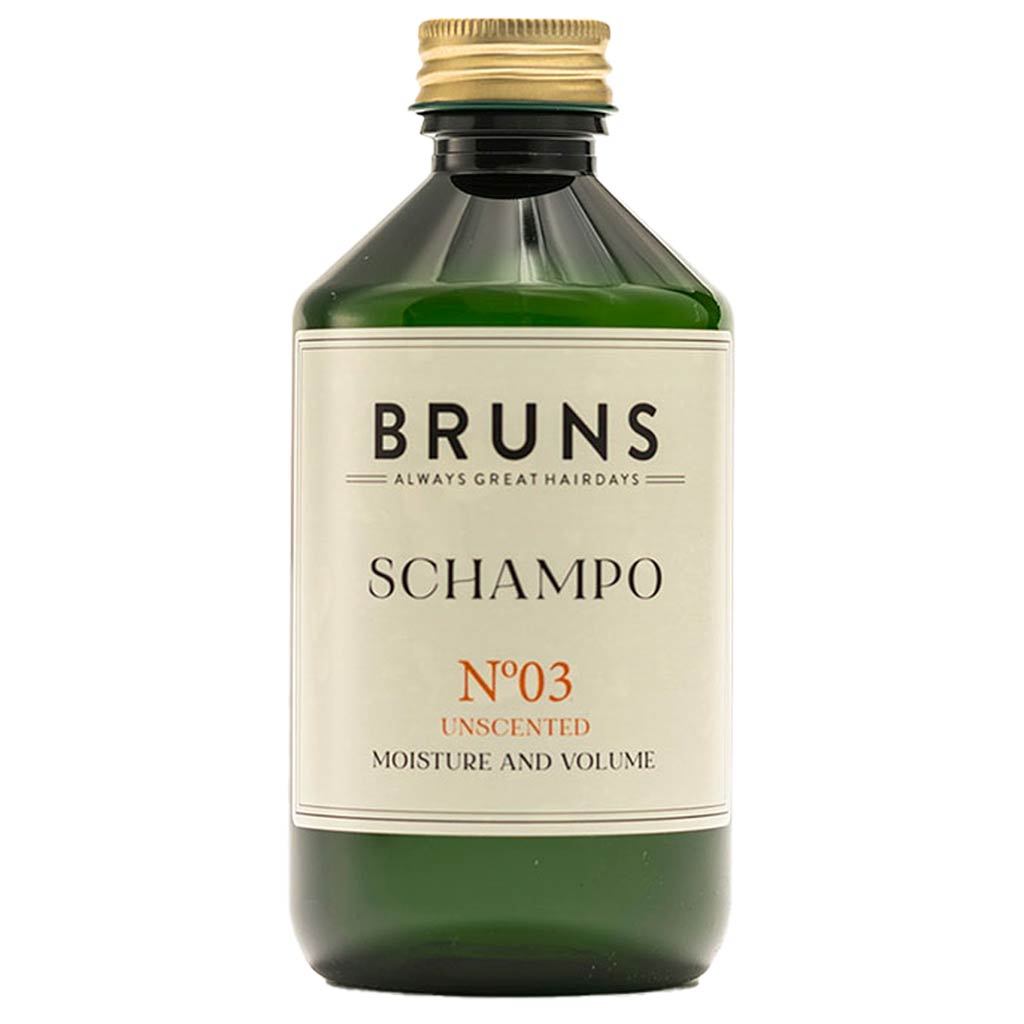 BRUNS Products Nº03 Hajusteeton Shampoo; vihreä muovipullo kultaisella, mattapintaisella kierrekorkilla; etiketissä mustaa ja kultaista groteskitypografiaa tekstillä "BRUNS SCHAMPO N°03 UNSCENTED MOISTURE AND VOLUME" sekä iskulause "ALWAYS GREAT HAIRDAYS"; pullo lieriömäinen suorin sivuin; tausta valkoinen, ei ihmisiä tai käsiä kuvassa.