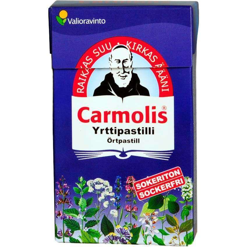 Carmolis Yrttipastilli -pakkaus; sininen, mattapintainen ja suorakulmainen rasia; kuvituksena iäkäs mies yrttien ja kukkien ympäröimänä; lihavoitua punaista ja valkoista tekstiä, mukaan lukien maininta sokerittomuudesta, tekstausvapaalla kirjasimella; kuvattu yksiväristä taustaa vasten, ei ihmisiä tai käsiä näkyvissä.