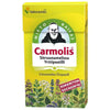 Carmolis Yrttipastilli Sitruunamelissa -pakkaus; keltainen, suorakulmainen ja mattapintainen pahvirasia; kuvituksena mies ja erilaisia yrttejä sekä suomen- ja ruotsinkielinen teksti; brändin nimi mustalla päätekirjasimella valkoisella kentällä, tuotetiedot sinisellä tekstausvapaalla kirjasimella; vaaleanpunaisessa etiketissä valkoinen teksti "Sokeriton Sockerfri"; kuvattu yksiväristä taustaa vasten, ei ihmisiä tai käsiä näkyvissä.