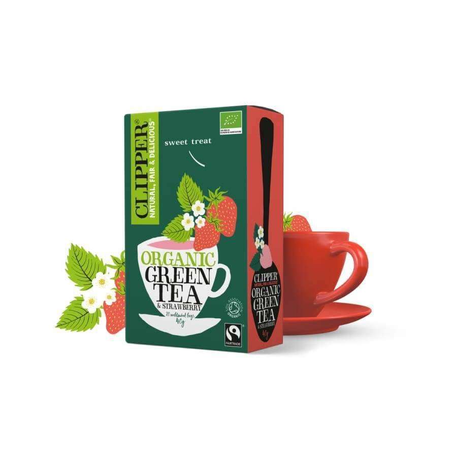 Clipper Luomu Vihreä Mansikka tee; rasia tekstillä "Clipper organic green tea" mansikanmaulla seisoo punaisen teekupin ja aluslautasen vieressä; teerasia suorakulmainen mattapahvia, kuvitettuna mansikoin ja vihrein lehdin; etikettiteksti lihavoiduin valkoisin suuraakkosin tummalla pohjalla; punainen keraaminen kuppi kiiltäväpintainen; kaikki neutraalilla pinnalla, ei ihmisiä kuvassa.