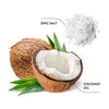 Ecodenta Anti-Plaque Hammaskiveä Ehkäisevä Hammastahna; halkaistu kookospähkinä vihrein lehdin, etiketöity Coconut Oil, kasan valkoisia kiteitä vieressä etiketöitynä Zinc Salt, ympäröitynä hienovaraisin luonnollisuuden vihjein valkoisella taustalla; valkoiset mattakiteet muodostavat pienen kasan ruskeankuorisen kookospähkinän vieressä; molemmilla yksinkertaiset painetut etiketit selkeällä groteskifontilla; asetelma minimalistinen ilman ihmisiä, kuvattu ylhäältä.