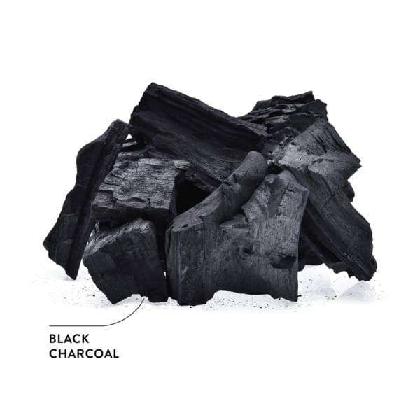 Ecodenta Black Whitening -valkaiseva hammastahna; kasa karkeita, mustia aktiivihiilipaloja valkoisella taustalla, muodoltaan epäsäännöllisiä, pinta mattaa ja särmikkäitä reunoja; nuolella varustettu suuraakkosin merkintä "BLACK CHARCOAL" osoittaa hiileen; ei pakkausta, ihmisiä tai käsiä; lähikuva tuotteesta.